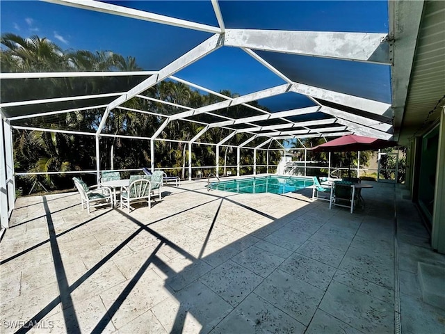 outdoor pool featuring glass enclosure and a patio area