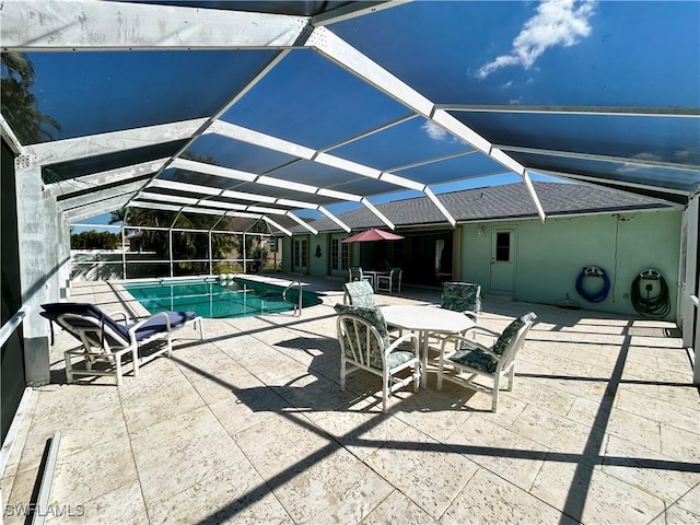 pool featuring glass enclosure and a patio area