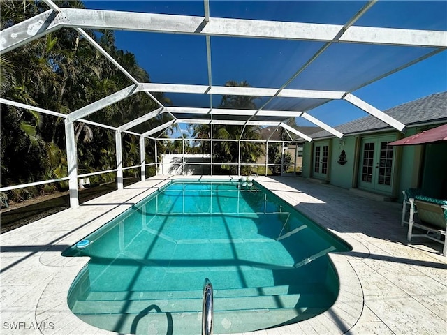 outdoor pool featuring a lanai, a patio area, and french doors