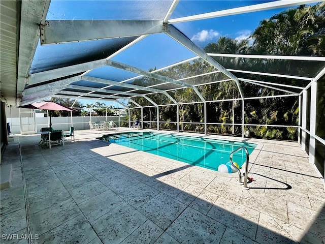 view of pool with a lanai, fence, a fenced in pool, and a patio