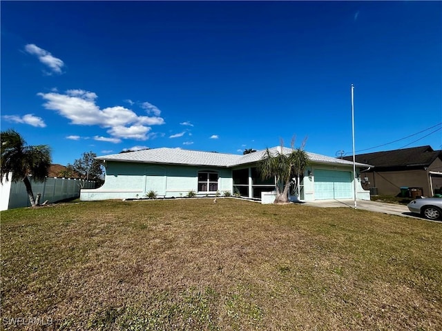 view of front of house with a garage, fence, and a front yard