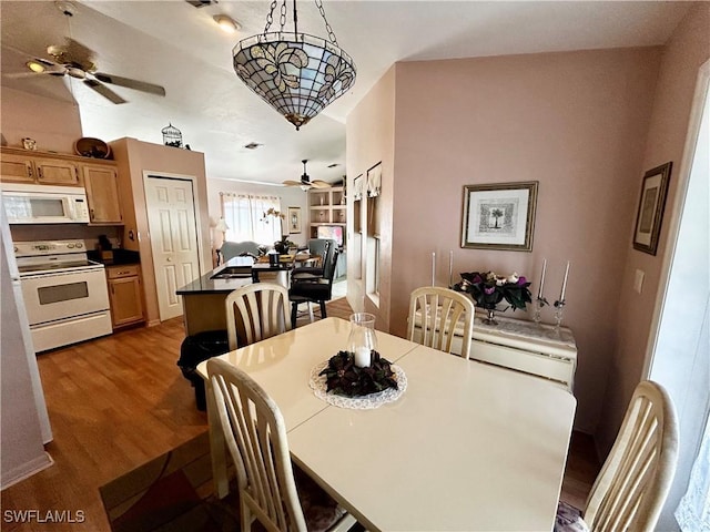 dining area featuring visible vents, a ceiling fan, and wood finished floors