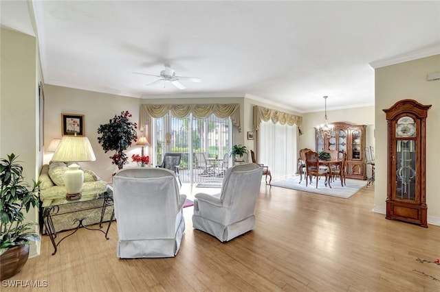 living room with ceiling fan with notable chandelier, ornamental molding, and light wood-style flooring