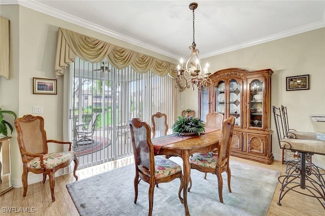 dining space featuring light wood-style floors, a chandelier, and ornamental molding