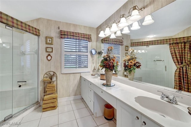 bathroom with tile patterned flooring, a sink, a shower stall, double vanity, and wallpapered walls