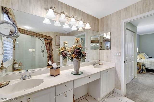 full bathroom featuring double vanity, a stall shower, a sink, and tile patterned floors