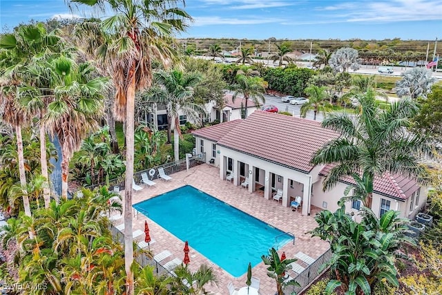 community pool with a patio area and a fenced backyard