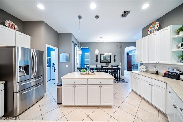 kitchen with arched walkways, white cabinetry, stainless steel fridge with ice dispenser, and open shelves