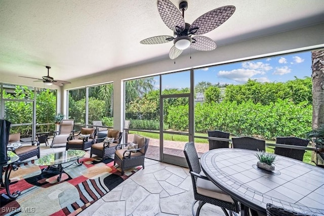 sunroom / solarium featuring a healthy amount of sunlight and ceiling fan