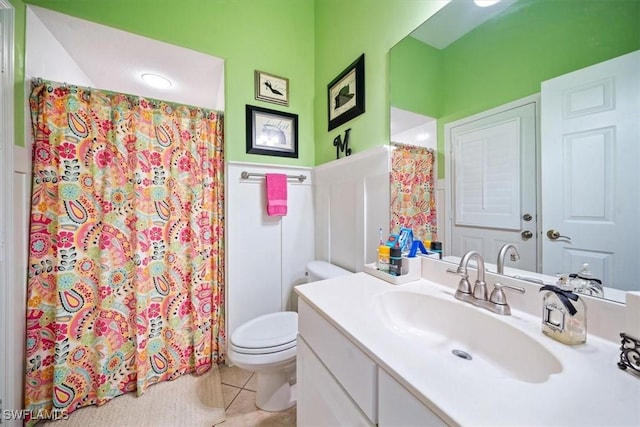 full bath featuring wainscoting, toilet, a shower with curtain, tile patterned flooring, and vanity