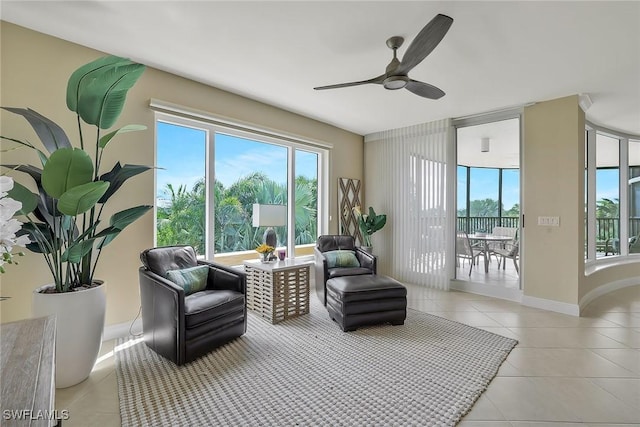 living area with a wealth of natural light, light tile patterned flooring, and baseboards