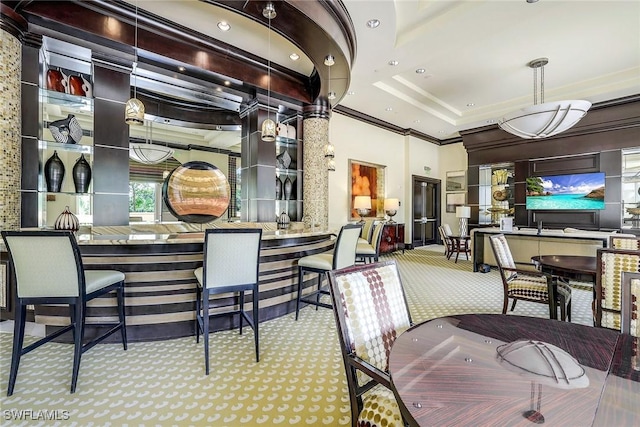 carpeted dining area with a high ceiling, a community bar, and crown molding