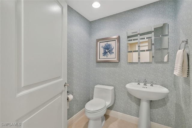 bathroom featuring toilet and baseboards