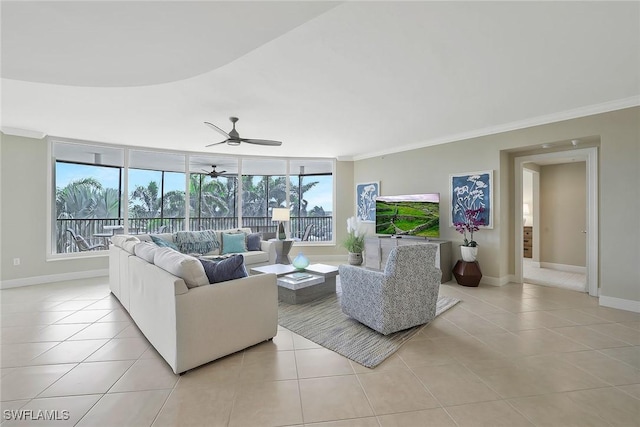 living room featuring light tile patterned floors, baseboards, ornamental molding, and a ceiling fan