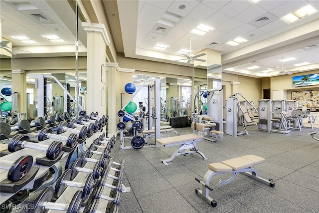 gym with a ceiling fan, a paneled ceiling, and visible vents