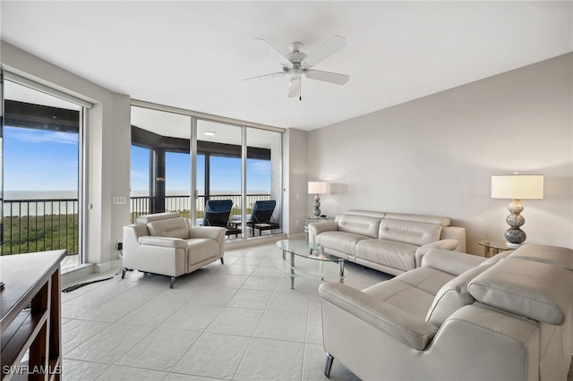 living area featuring plenty of natural light, expansive windows, a ceiling fan, and light tile patterned flooring