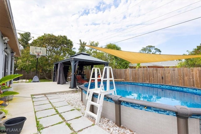 view of swimming pool featuring a fenced backyard, a patio, a fenced in pool, and a gazebo