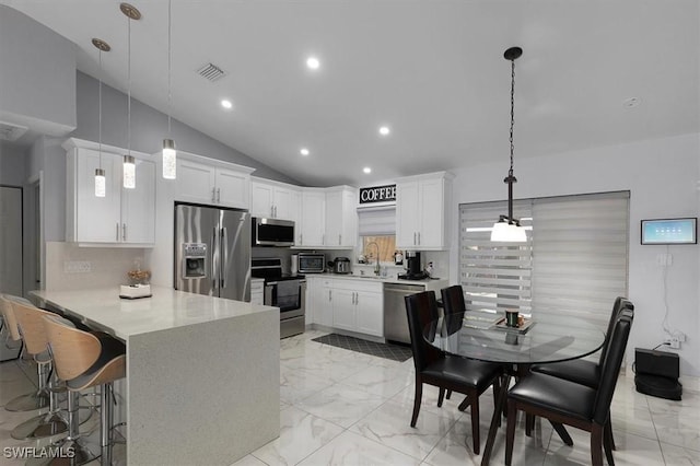 kitchen with marble finish floor, a peninsula, appliances with stainless steel finishes, and visible vents