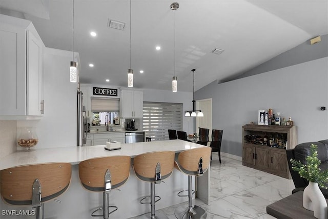 kitchen with stainless steel appliances, visible vents, white cabinetry, a sink, and a peninsula