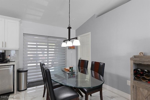 dining space with marble finish floor, baseboards, and vaulted ceiling