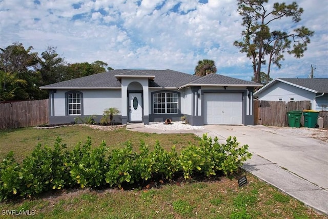 ranch-style home featuring a garage, concrete driveway, fence, a front yard, and stucco siding