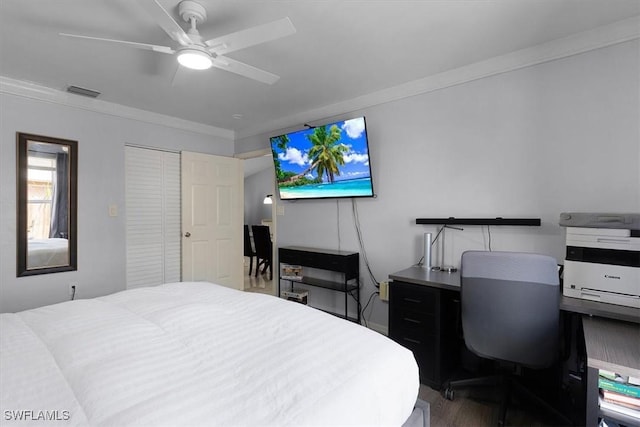 bedroom with crown molding, a closet, visible vents, a ceiling fan, and wood finished floors