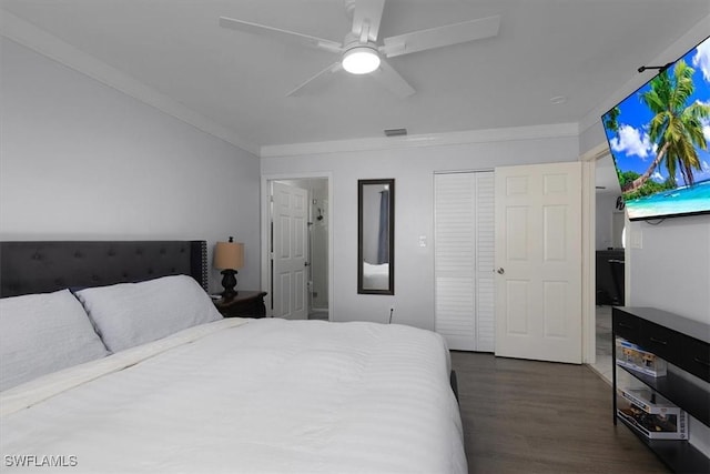 bedroom featuring dark wood finished floors, a closet, visible vents, ornamental molding, and a ceiling fan