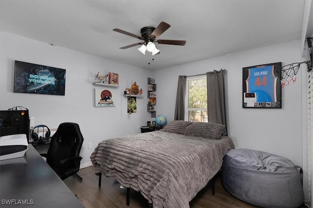 bedroom featuring ceiling fan, baseboards, and wood finished floors