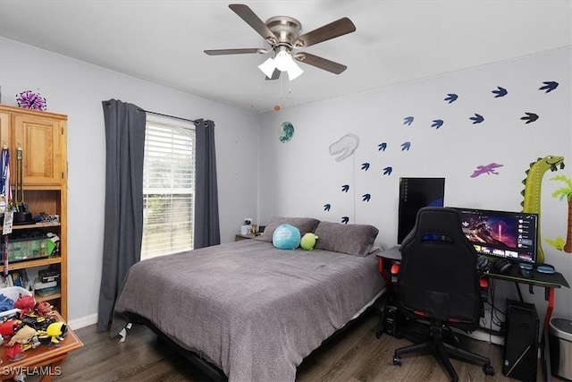 bedroom with ceiling fan, baseboards, and wood finished floors