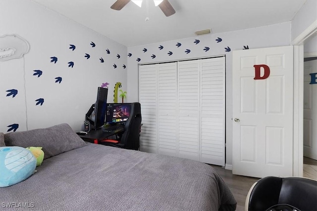 bedroom with ceiling fan, a closet, wood finished floors, and visible vents