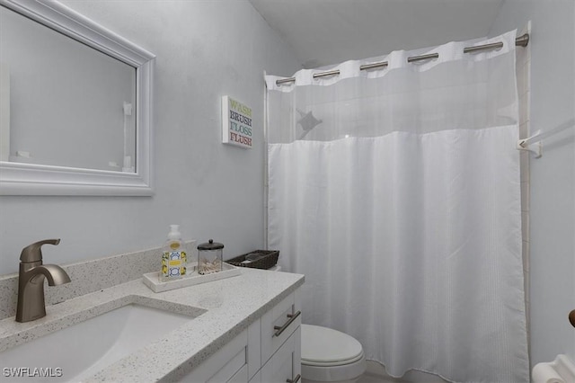 full bathroom featuring a shower with shower curtain, vanity, and toilet