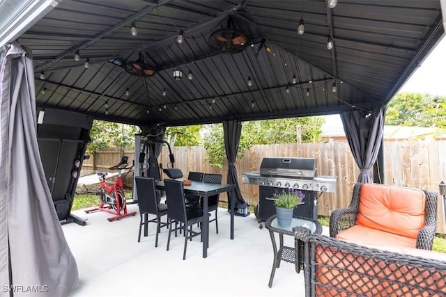 view of patio / terrace featuring grilling area, fence, outdoor dining area, and a gazebo