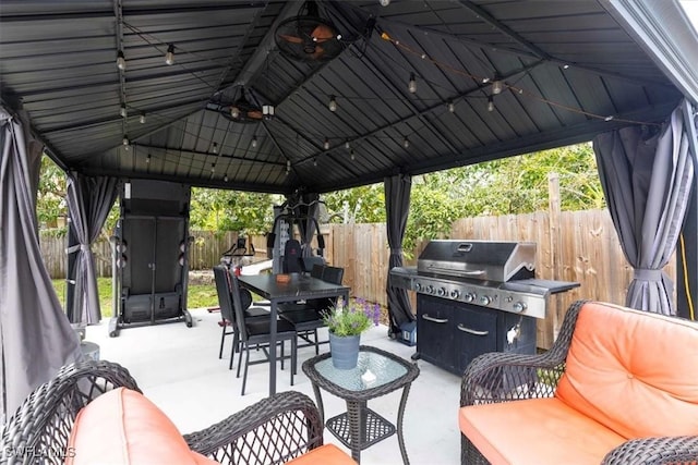 view of patio featuring outdoor dining space, outdoor lounge area, fence, and a gazebo