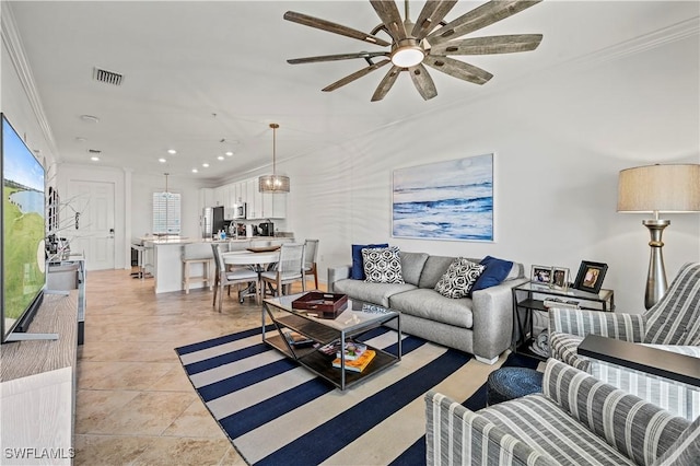 living area featuring visible vents, ornamental molding, a ceiling fan, and light tile patterned flooring