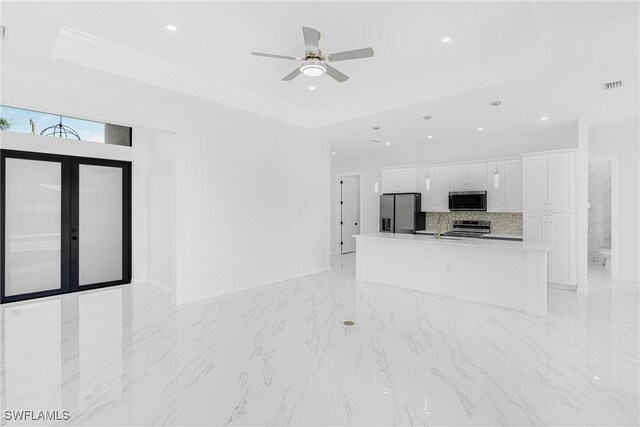 unfurnished living room with recessed lighting, visible vents, marble finish floor, a tray ceiling, and crown molding