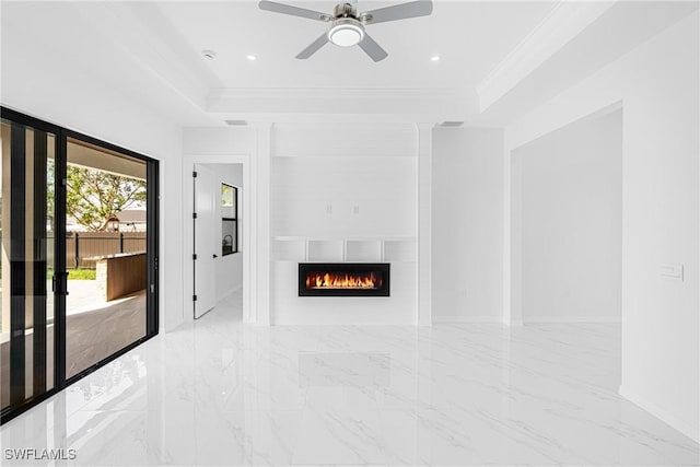 unfurnished living room with marble finish floor, a fireplace, ornamental molding, and a raised ceiling