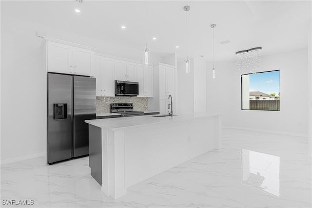 kitchen featuring marble finish floor, stainless steel appliances, a sink, and white cabinetry