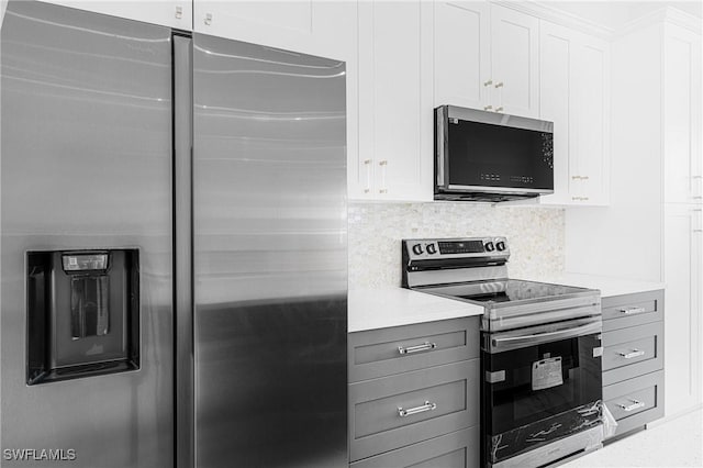 kitchen with white cabinets, appliances with stainless steel finishes, and decorative backsplash