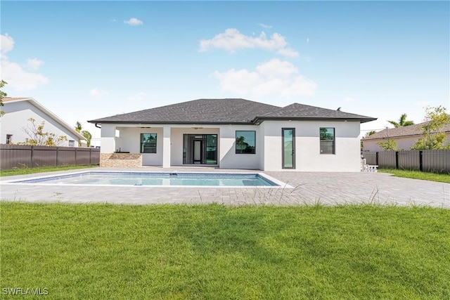 rear view of property with ceiling fan, fence, and a lawn