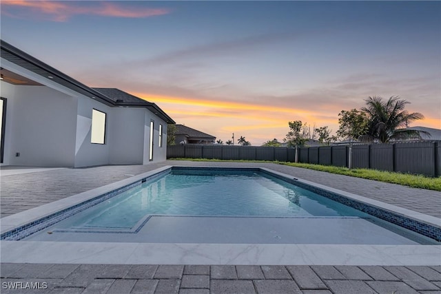 pool at dusk with a fenced in pool, fence, and a patio