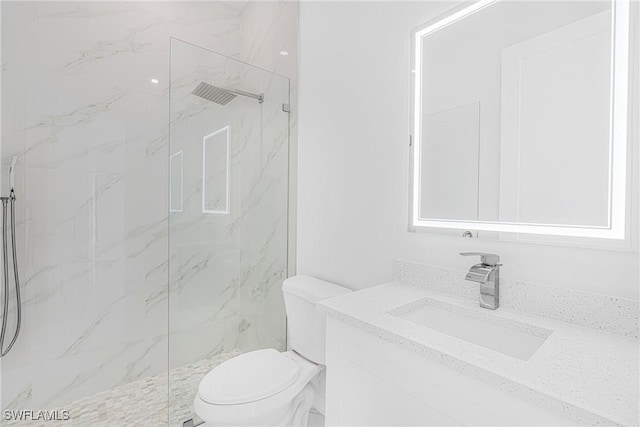 bathroom with vanity, a marble finish shower, and toilet