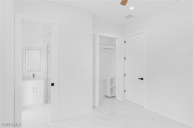 hall with baseboards, visible vents, marble finish floor, a sink, and recessed lighting