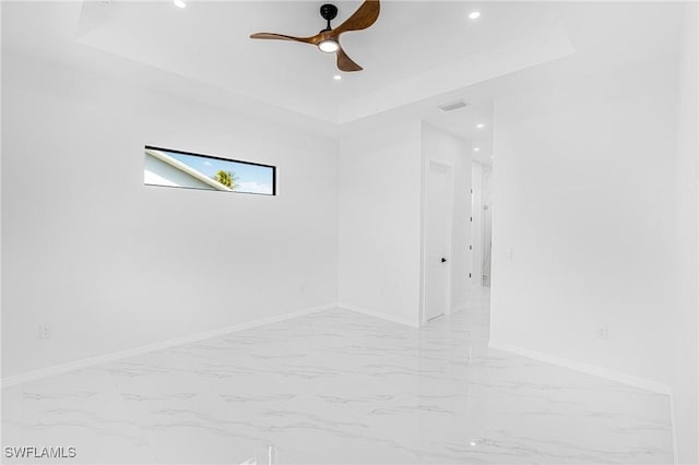 unfurnished room featuring recessed lighting, visible vents, baseboards, marble finish floor, and a tray ceiling