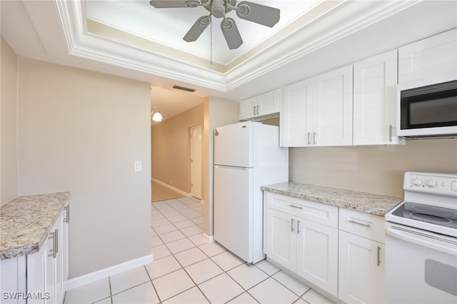 kitchen featuring ornamental molding, a tray ceiling, white appliances, and white cabinetry