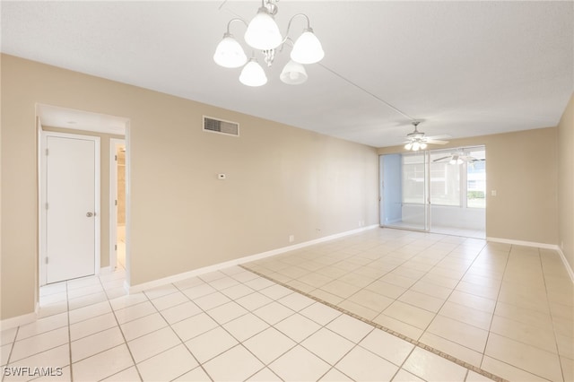 unfurnished room featuring light tile patterned floors, baseboards, visible vents, and ceiling fan with notable chandelier