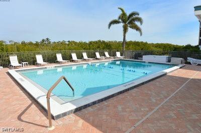 community pool with fence and a patio