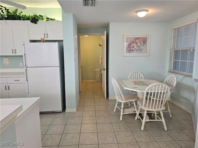 dining room featuring light tile patterned flooring, visible vents, and baseboards