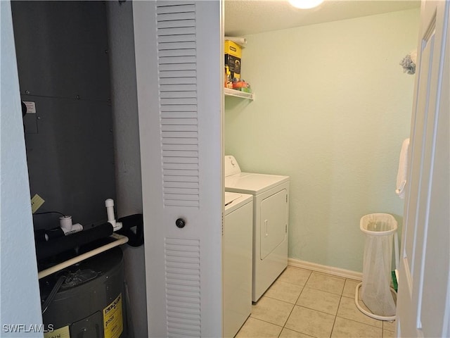 clothes washing area featuring laundry area, light tile patterned floors, and baseboards