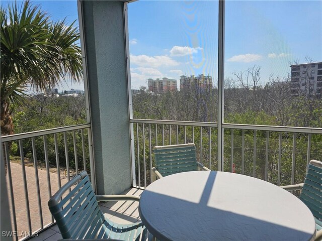 balcony featuring outdoor dining area and a city view