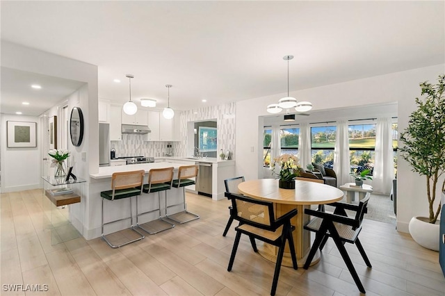 dining space with light wood-style flooring, baseboards, and recessed lighting